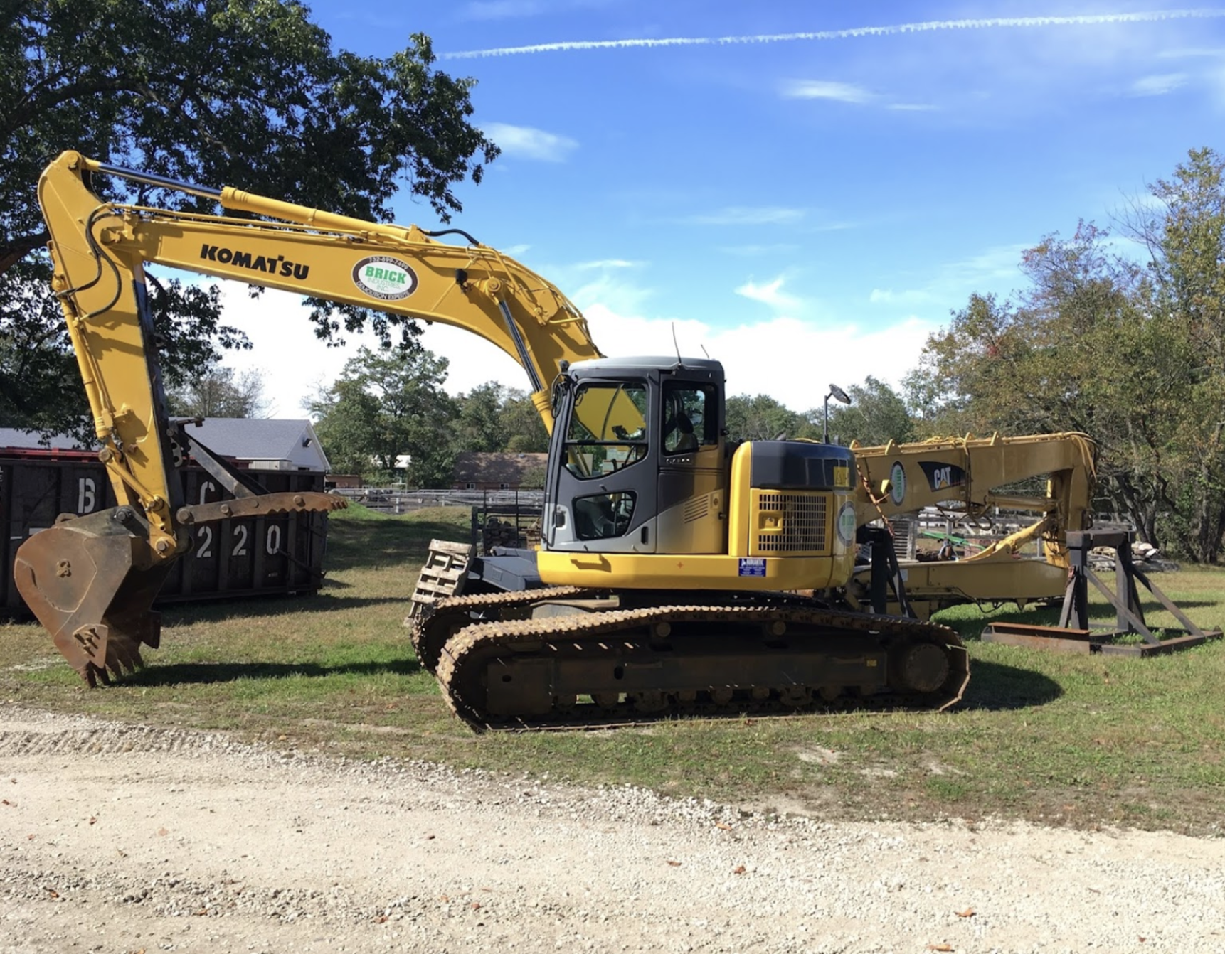 A yellow excavator sits atop a dirt field, showcasing heavy machinery in a work environment.