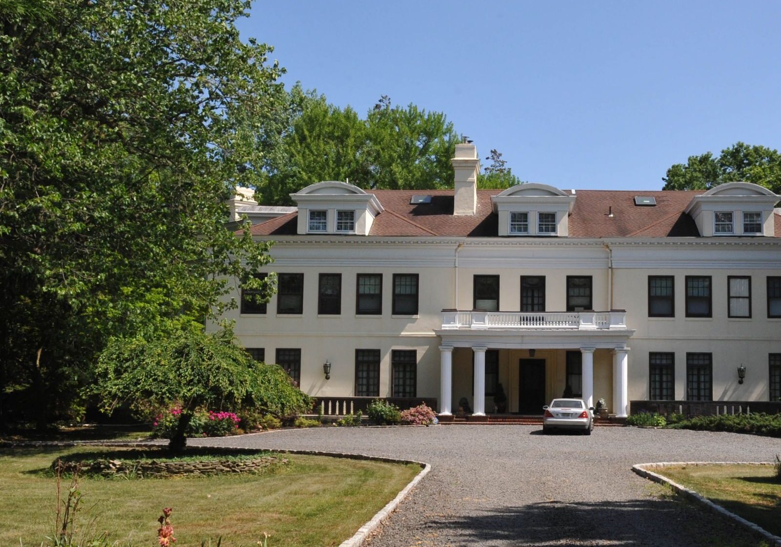 Spacious property in Rumson with a large estate home and well-kept driveway surrounded by trees and landscaping.