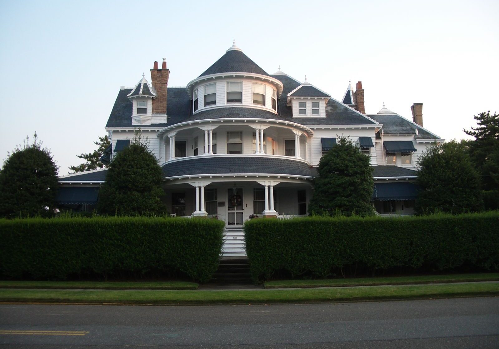 Spring Lake residential area with an elegant traditional house, large trees, and a sidewalk leading to the entrance.